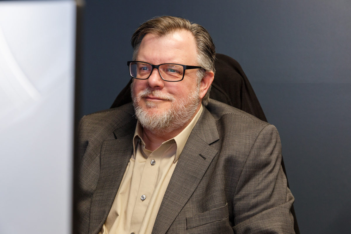 A man smiling at a computer screen