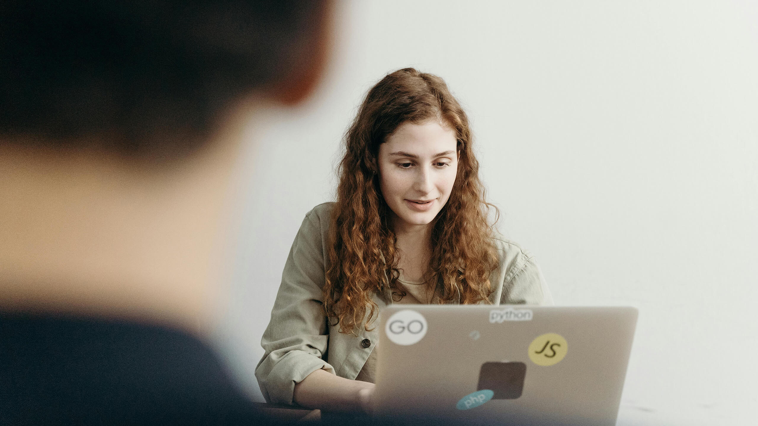 A woman sitting and working on a laptop for co-managed IT service.